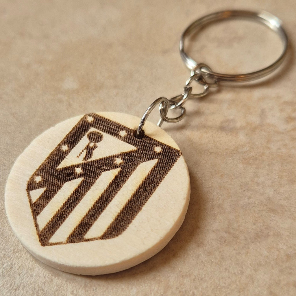 Llavero artesanal fabricado en madera natural, cortado y grabado mediante tecnología láser de alta precisión.

Presenta un diseño circular de acabado suave, con grabado permanente de gran definición que resalta el escudo del Atlético de Madrid con un contraste elegante y duradero.

Incluye resistente aro metálico con cadena, ideal para llaves, mochilas...

Gracias a su ligereza y estilo natural, es perfecto como regalo personalizado o detalle ecológico.

Grabado a doble cara.

¡Contacta con nosotros para pe