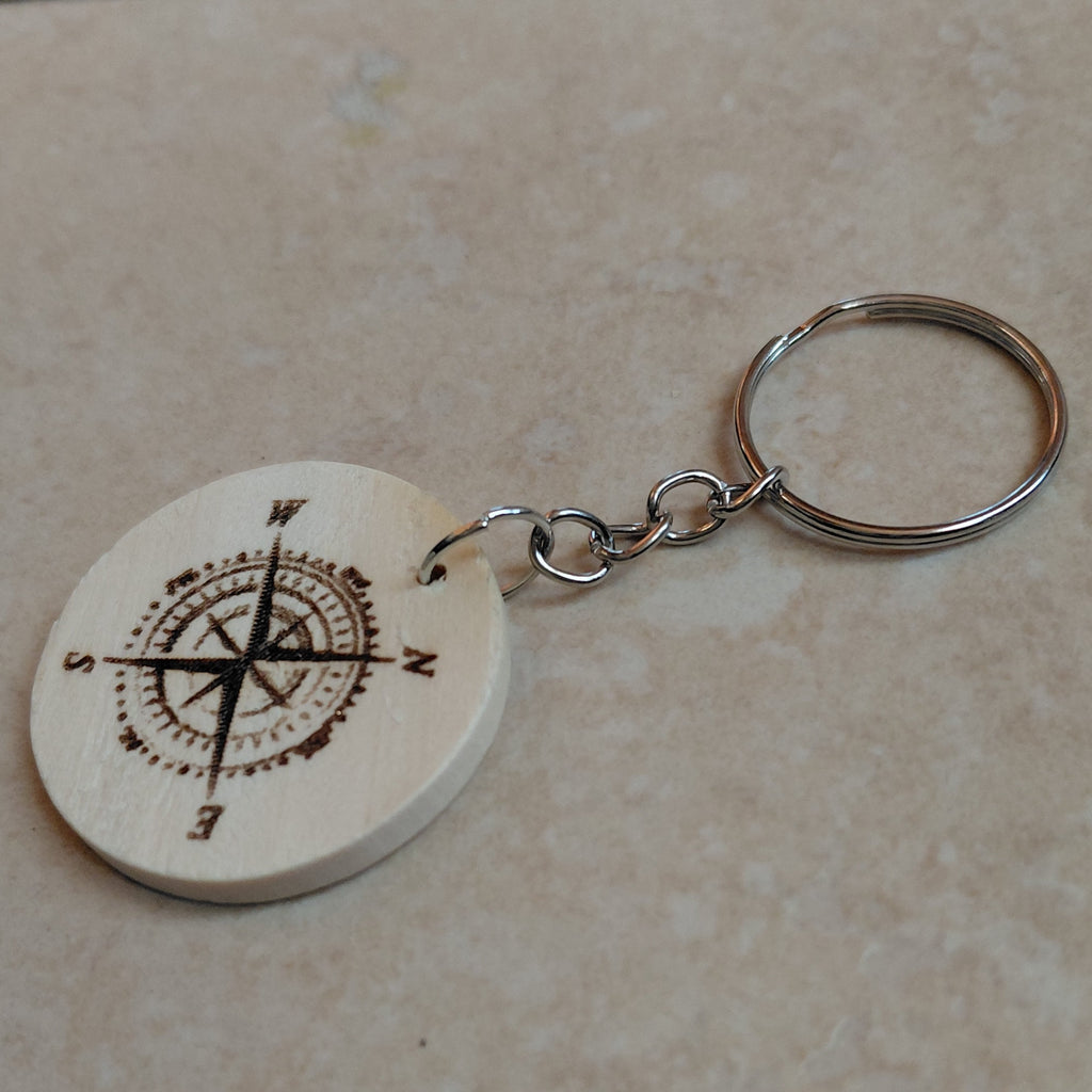 Llavero artesanal de madera grabado láser redondo con la imagen de na brujula, ideal para regalar a excursionistas