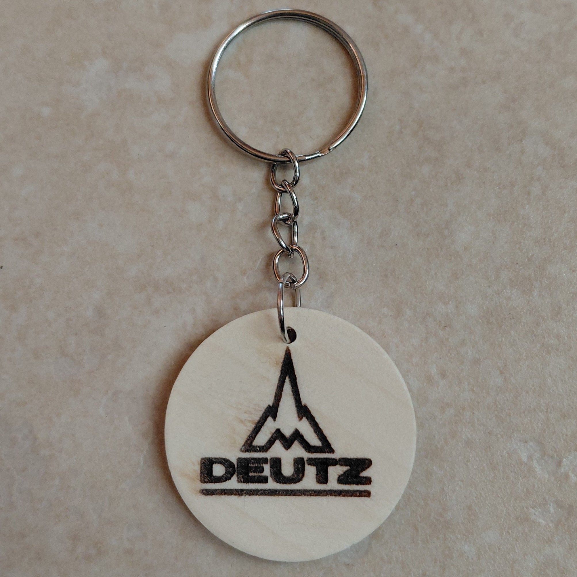 Llavero artesanal de madera grabado láser con el logo de la marca de tractores Deutz