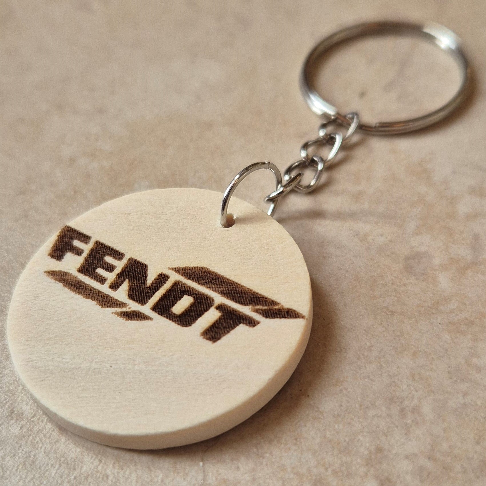 Llavero artesanal fabricado en madera natural, cortado y grabado mediante tecnología láser de alta precisión.

Presenta un diseño circular de acabado suave, con grabado permanente de gran definición que resalta el logotipo de la marca de tractores Fendt con un contraste elegante y duradero.

Incluye resistente aro metálico con cadena, ideal para llaves, mochilas...

Gracias a su ligereza y estilo natural, es perfecto como regalo personalizado o detalle ecológico.