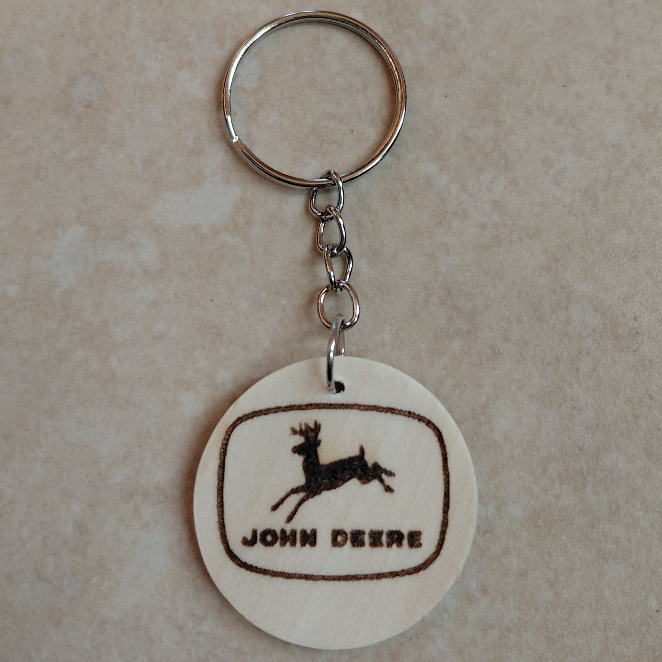 Llavero artesanal de madera grabado láser con el logo de la marca de tractores John Deere