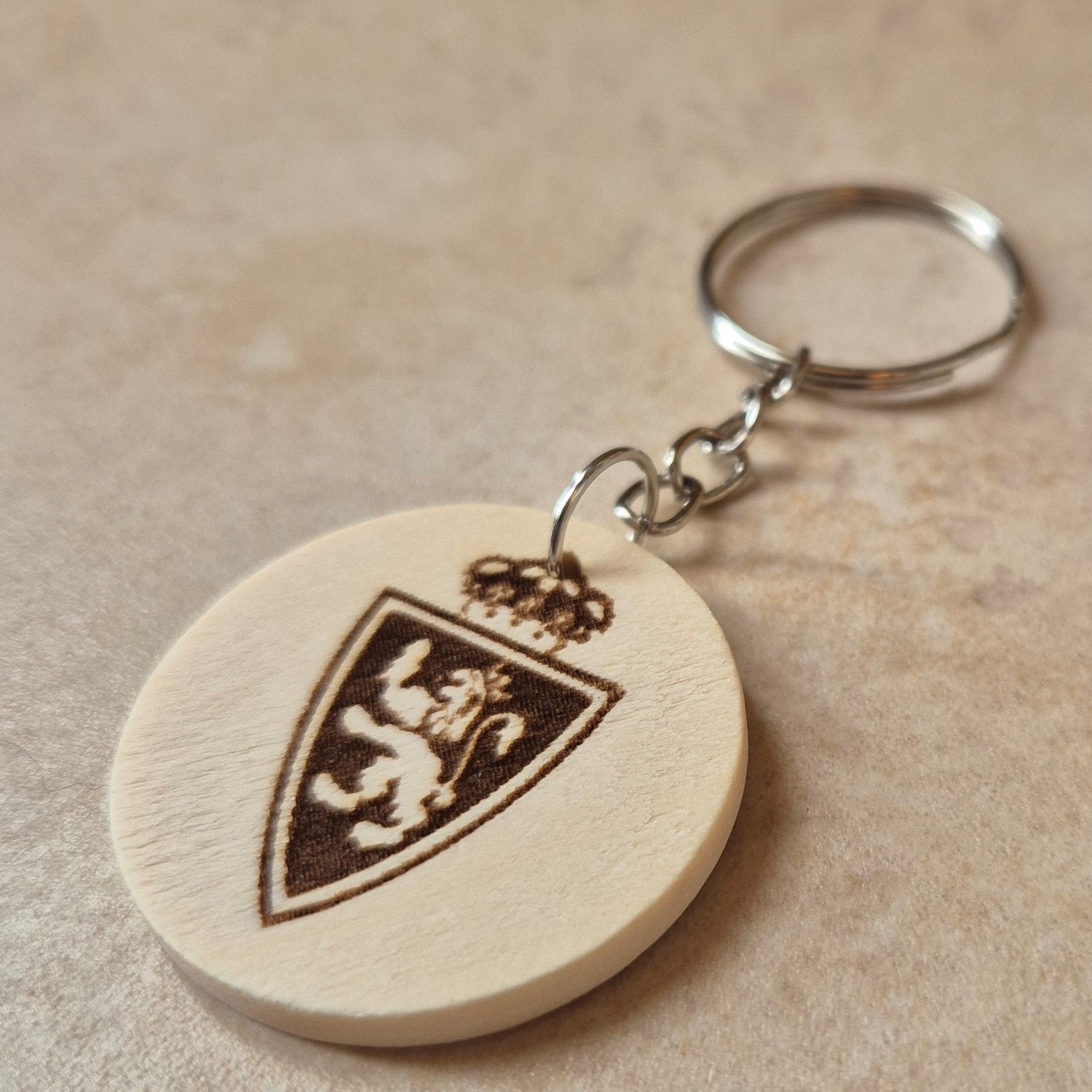 Llavero artesanal fabricado en madera natural, cortado y grabado mediante tecnología láser de alta precisión.

Presenta un diseño circular de acabado suave, con grabado permanente de gran definición que resalta el escudo del Real Zaragoza con un contraste elegante y duradero.

Incluye resistente aro metálico con cadena, ideal para llaves, mochilas...

Gracias a su ligereza y estilo natural, es perfecto como regalo personalizado o detalle ecológico.

Grabado a doble cara.

¡Contacta con nosotros para persona