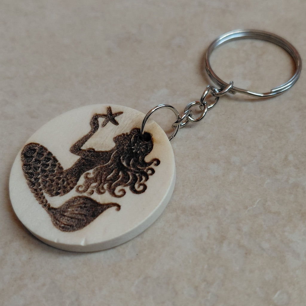 Llavero artesano de madera grabado a láser con la imagen de una preciosa sirena con una estrella de mar en las manos