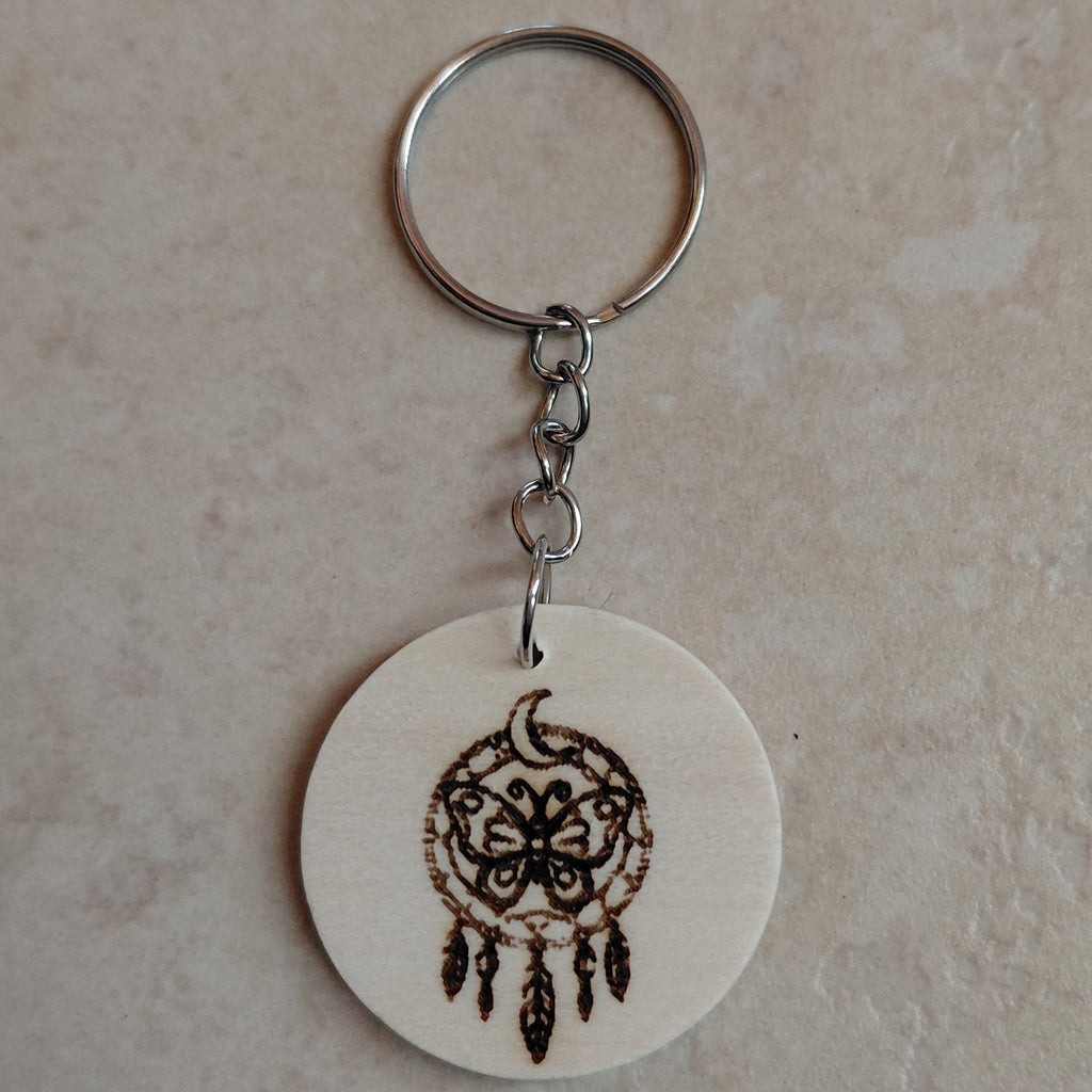 Llavero  artesano de madera grabado a láser con una imagen de un atrapasueños y una mariposa