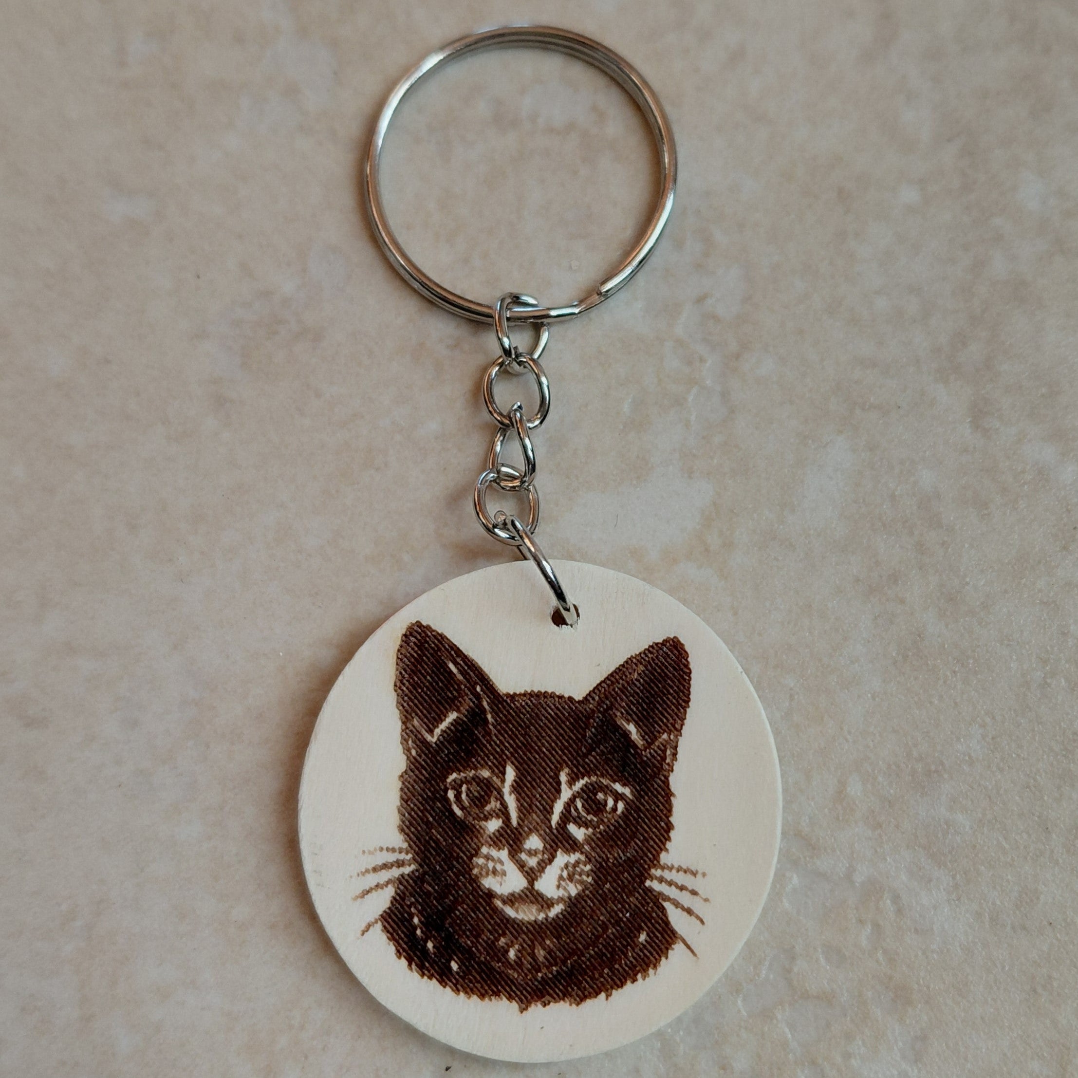 Llavero artesano de madera grabado a láser con la imagen de un adorable gatito
