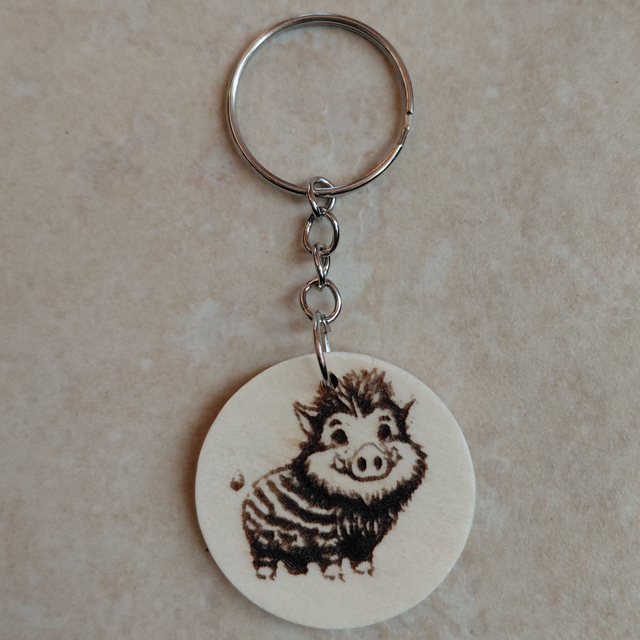Llavero artesano de madera grabado a láser con la imagen de un adorable jabalí