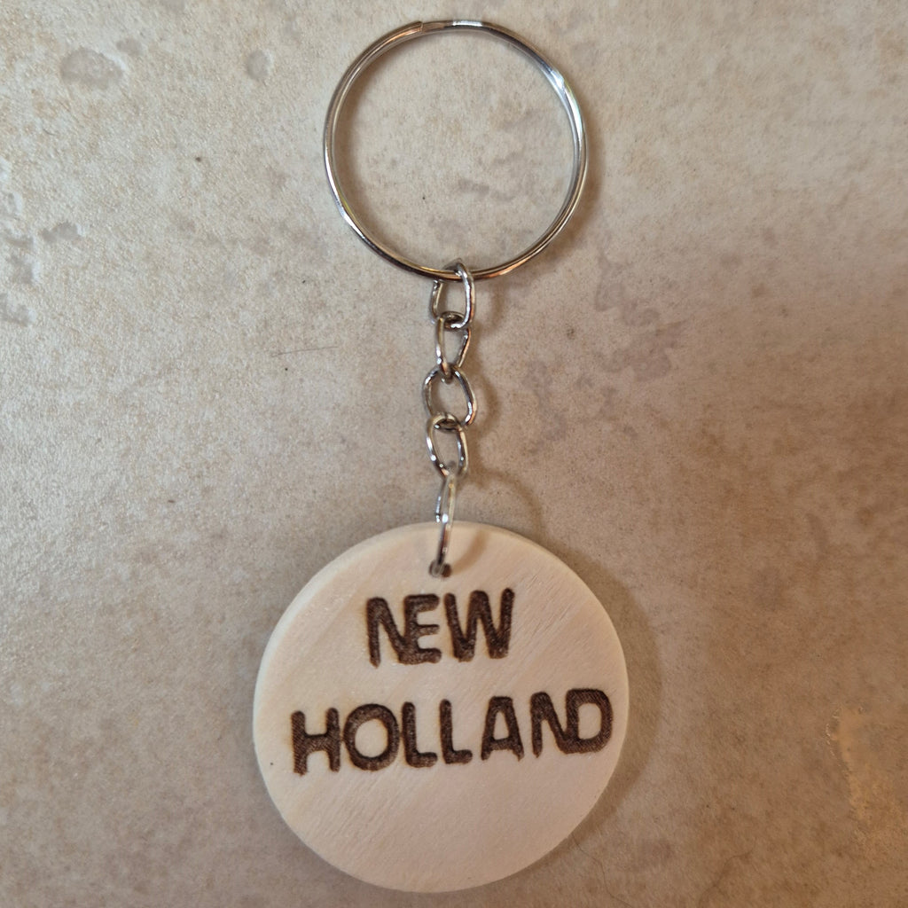 Llavero artesanal fabricado en madera natural, cortado y grabado mediante tecnología láser de alta precisión.

Presenta un diseño circular de acabado suave, con grabado permanente de gran definición que resalta el logotipo de la marca de tractores New Holland con un contraste elegante y duradero.

Incluye resistente aro metálico con cadena, ideal para llaves, mochilas...

Gracias a su ligereza y estilo natural, es perfecto como regalo personalizado o detalle ecológico.

Grabado a doble cara.

¡Contacta con 