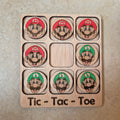 Hermoso juego de Tic-Tac-Toe (Tres en raya) artesanal, elaborado en madera natural mediante técnica de corte y grabado láser, y pintado completamente a mano con gran detalle y cuidado.

Incluye fichas ilustradas con los famosos personajes de Super Mario Bros (Mario y Luigi), lo que lo convierte en un artículo único, colorido y lleno de encanto, ideal tanto para jugar como para decorar.

Perfecto como regalo original, recuerdo artesanal o elemento decorativo para habitaciones infantiles, escritorios o estant