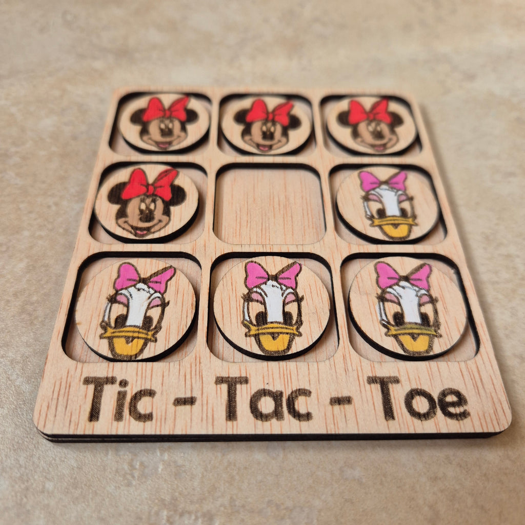 Hermoso juego de Tic-Tac-Toe (Tres en raya) artesanal, elaborado en madera natural mediante técnica de corte y grabado láser, y pintado completamente a mano con gran detalle y cuidado.

Incluye fichas ilustradas con los famosos personajes de Disney (Minnie y Daisy), lo que lo convierte en un artículo único, colorido y lleno de encanto, ideal tanto para jugar como para decorar.

Perfecto como regalo original, recuerdo artesanal o elemento decorativo para habitaciones infantiles, escritorios o estanterías.