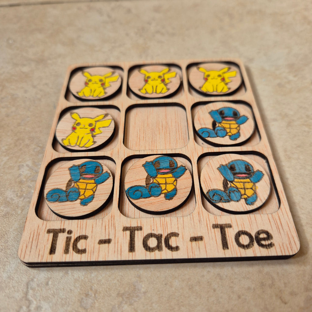 Hermoso juego de Tic-Tac-Toe (Tres en raya) artesanal, elaborado en madera natural mediante técnica de corte y grabado láser, y pintado completamente a mano con gran detalle y cuidado.

Incluye fichas ilustradas con los famosos personajes de Pokémon (Pikachu y Squirtle), lo que lo convierte en un artículo único, colorido y lleno de encanto, ideal tanto para jugar como para decorar.

Perfecto como regalo original, recuerdo artesanal o elemento decorativo para habitaciones infantiles, escritorios o estantería