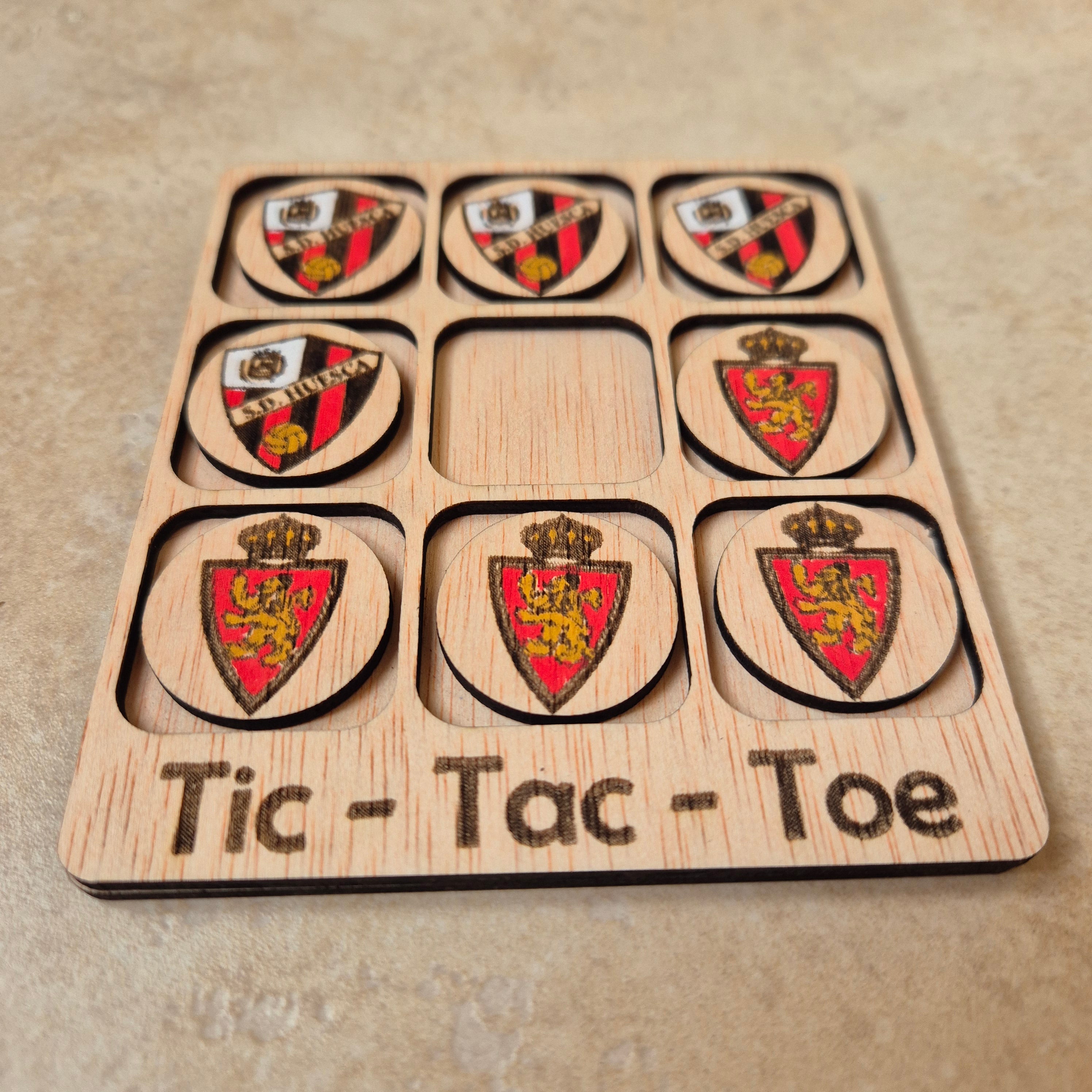 Hermoso juego de Tic-Tac-Toe (Tres en raya) artesanal, elaborado en madera natural mediante técnica de corte y grabado láser, y pintado completamente a mano con gran detalle y cuidado.

Incluye fichas ilustradas con los fantásticos clubs de fútbol de Aragón (S. D. Huesca y Real Zaragoza), lo que lo convierte en un artículo único, colorido y lleno de encanto, ideal tanto para jugar como para decorar.

Perfecto como regalo original, recuerdo artesanal o elemento decorativo para habitaciones infantiles, escrit