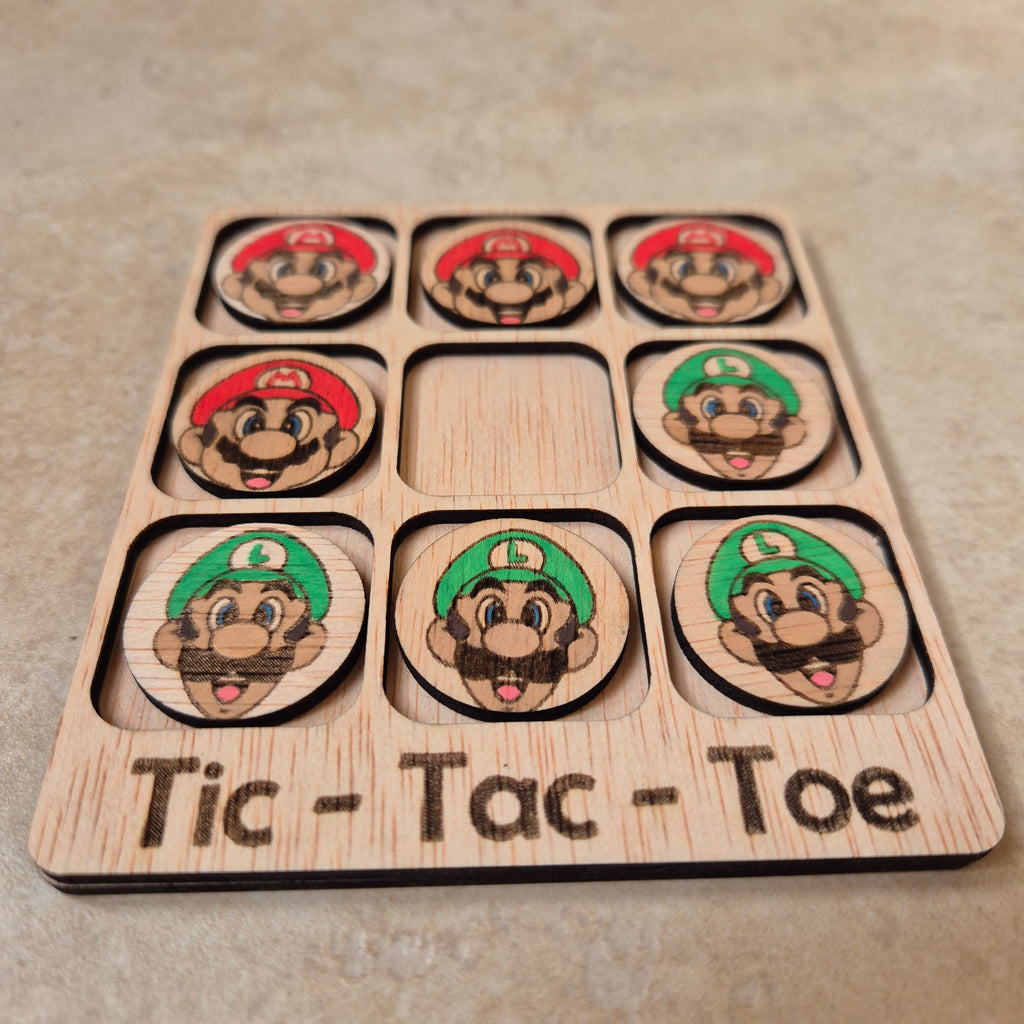 Hermoso juego de Tic-Tac-Toe (Tres en raya) artesanal, elaborado en madera natural mediante técnica de corte y grabado láser, y pintado completamente a mano con gran detalle y cuidado.

Incluye fichas ilustradas con los famosos personajes de Super Mario Bros (Mario y Luigi), lo que lo convierte en un artículo único, colorido y lleno de encanto, ideal tanto para jugar como para decorar.

Perfecto como regalo original, recuerdo artesanal o elemento decorativo para habitaciones infantiles, escritorios o estant